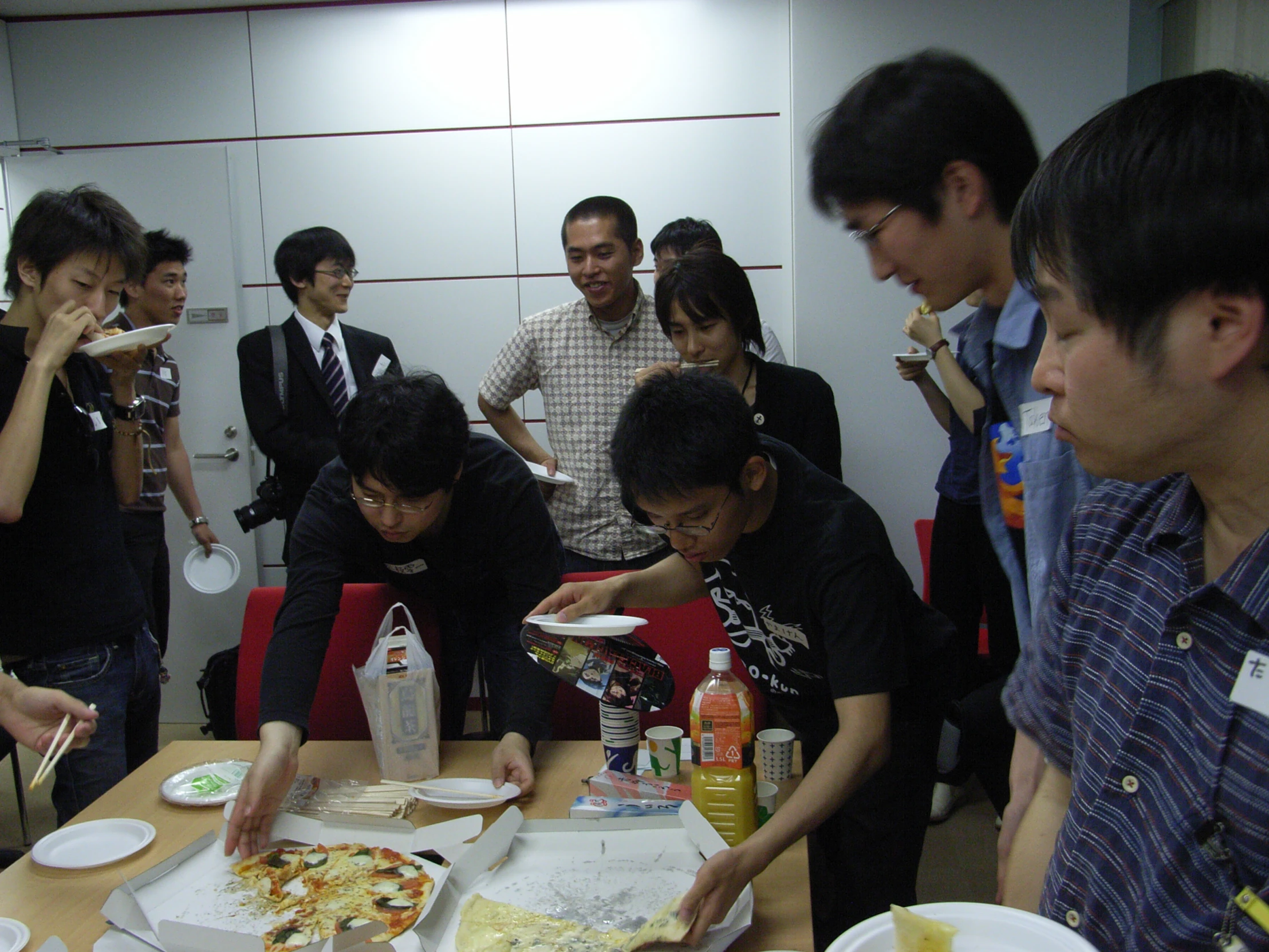 people eat pizza together at a conference