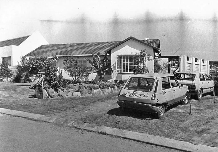 an old po of a house and truck parked on the side of the road