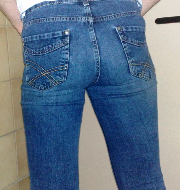 the back of a man's blue jeans in a restroom