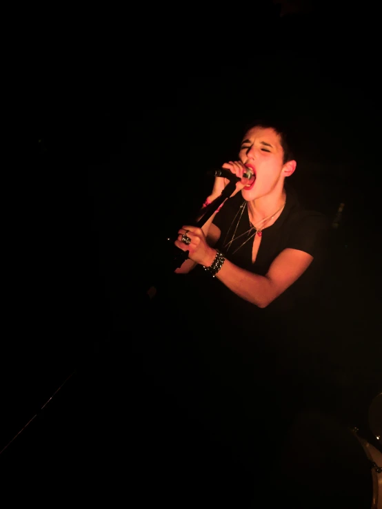 a man singing into a microphone at night