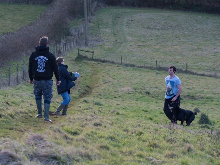 a group of people in a field with two dogs