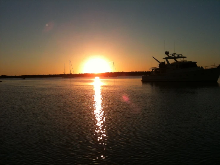 a large boat floating on top of a lake near a sun