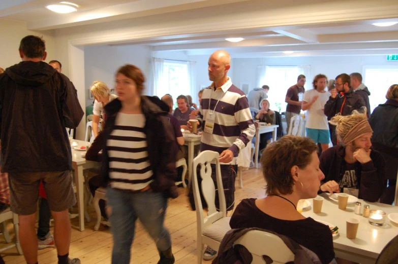 group of people eating at tables with cups in the background