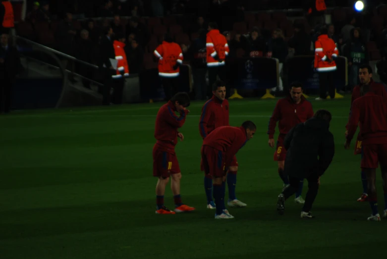 some soccer players standing on a field and some fans