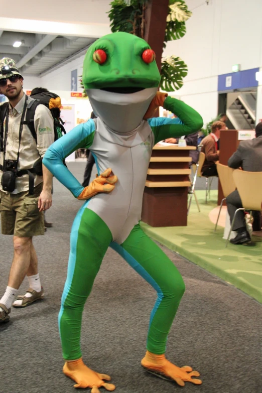 a man standing with his foot on the ground wearing an inflatable frog costume