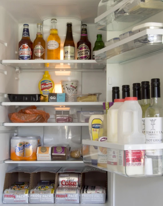 a refrigerator with food in the door and milk on display