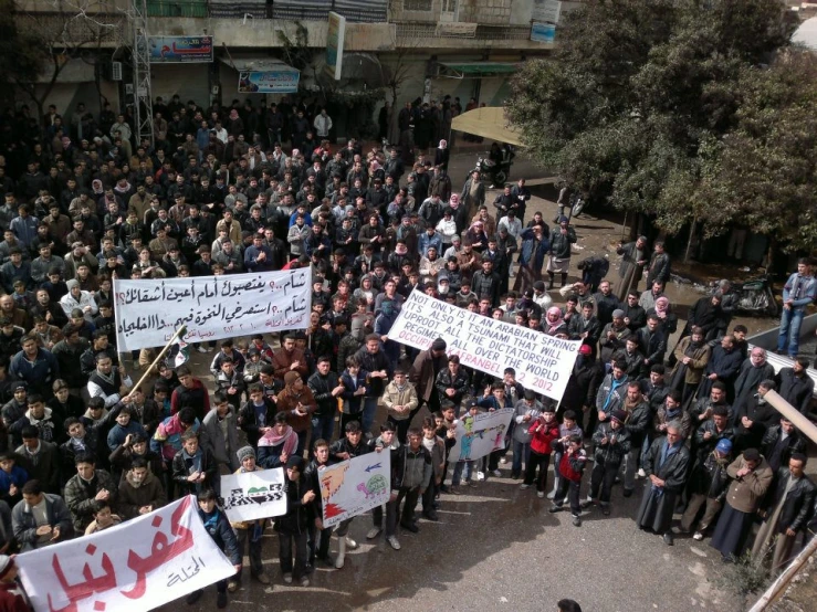 a group of people holding signs and placards