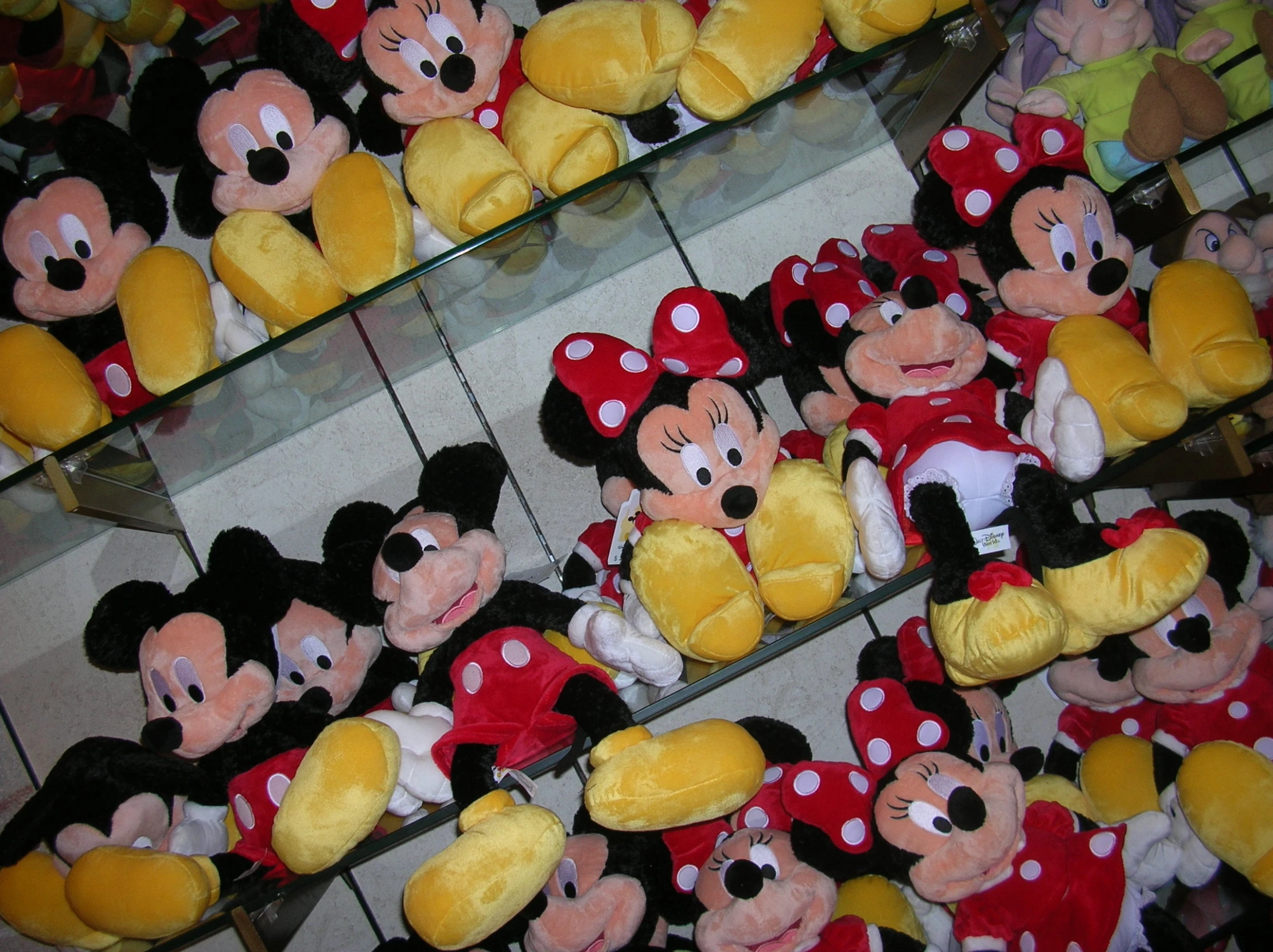 mickey and minnie mouse stuffed animals in various colors