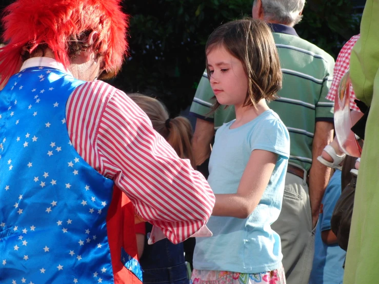 a little girl standing next to a woman in a costume