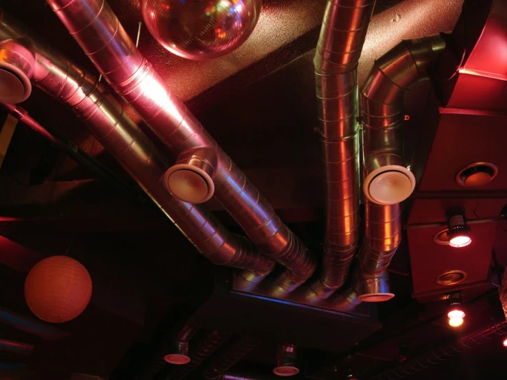 the light fixture is illuminating a ceiling with colorful metal pipes