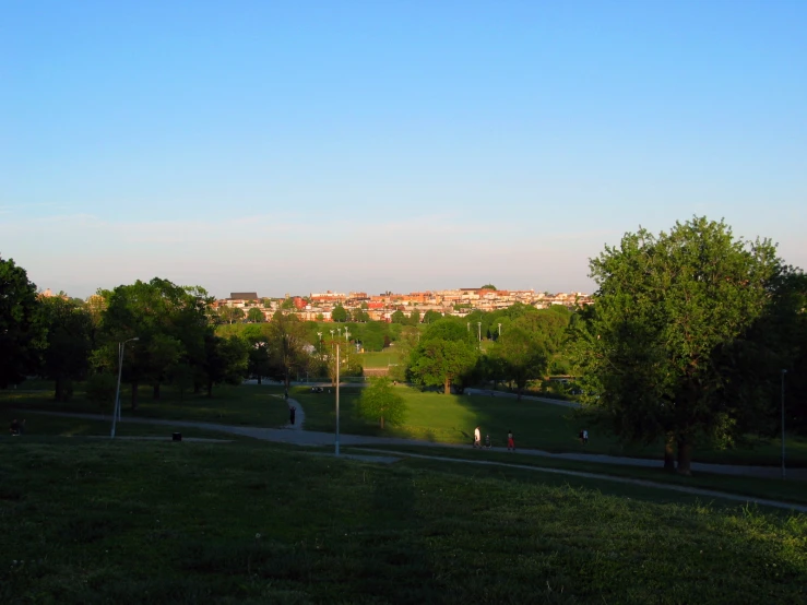 some people walking down the path near grass and trees