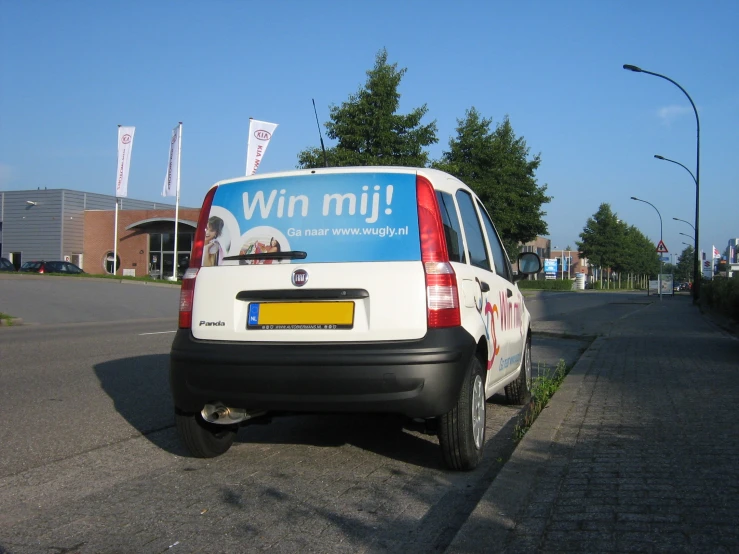 a vehicle parked on a city street near grass