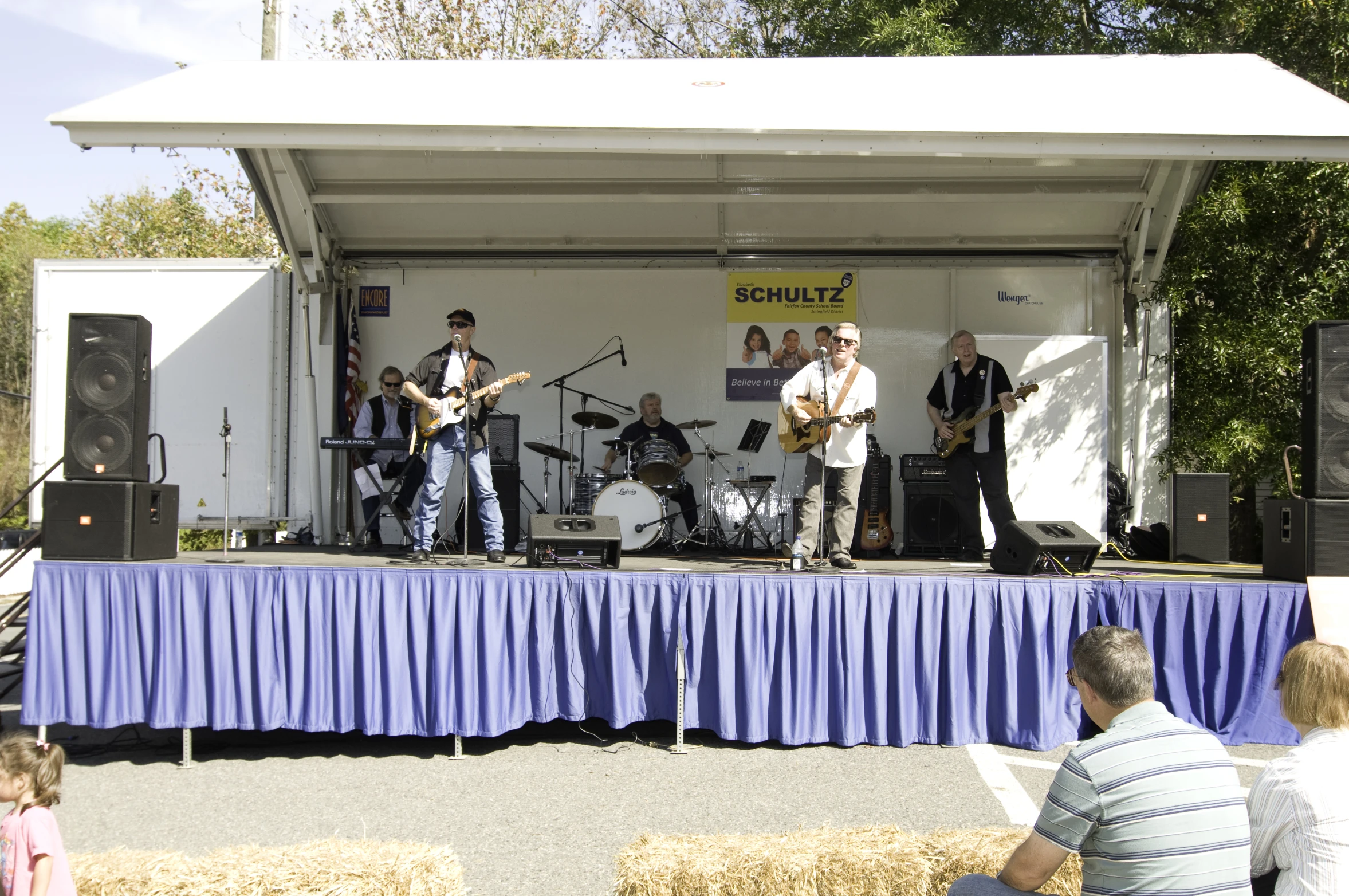 the band is playing in front of a large stage