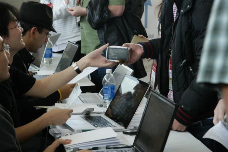 a group of people gathered together with their laptops