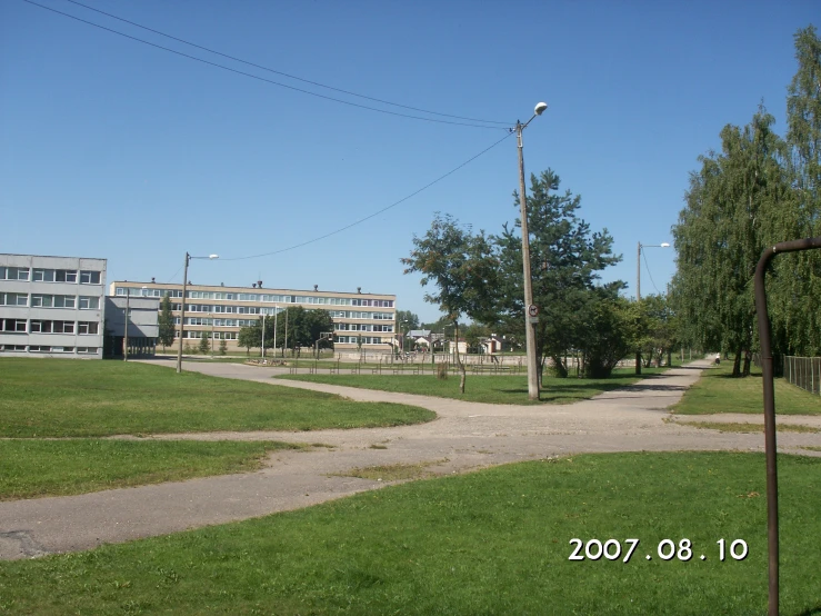 an empty road leads to a building and trees