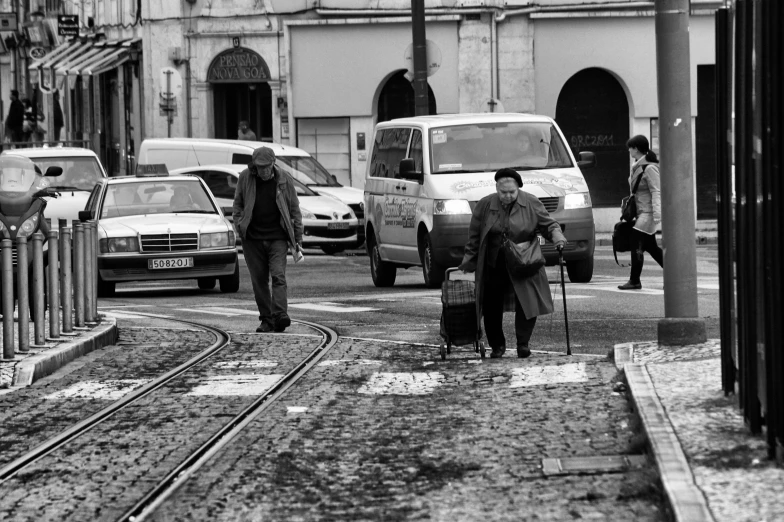 a man and woman with luggage are walking down the road