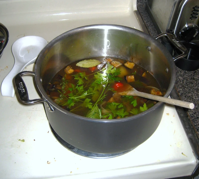 a pan filled with vegetables sits on the stove