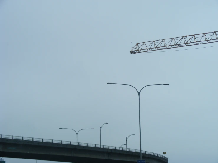 there is a crane and a bridge in the sky
