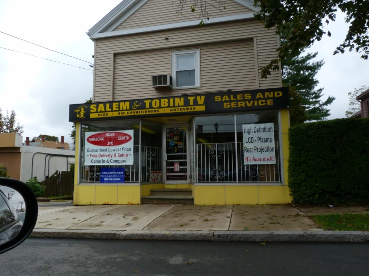 a yellow store with a sales ad in the front