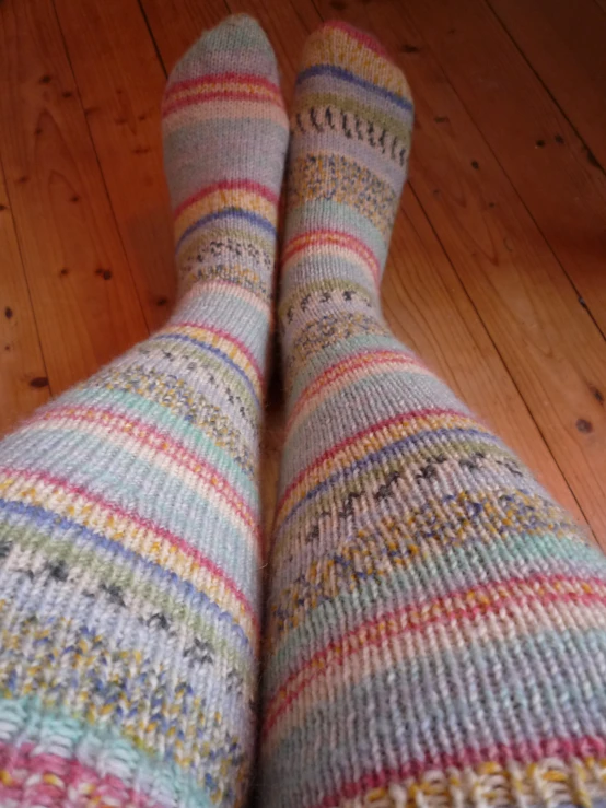 someone's legs and socks with multi colored knit