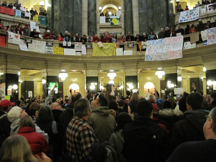 a large crowd of people sitting in an atrium