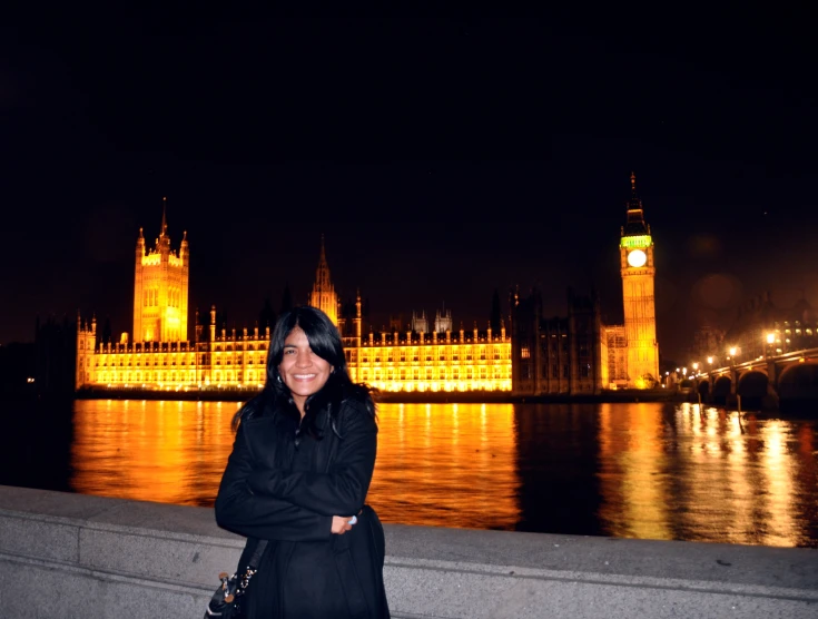 a lady stands in front of a large palace