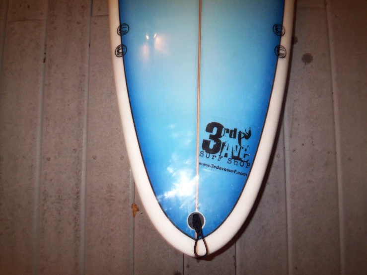 a large surfboard hanging from the wall