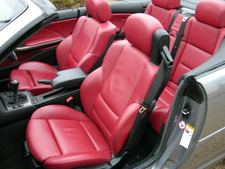 two front seats of a car with red vinyl