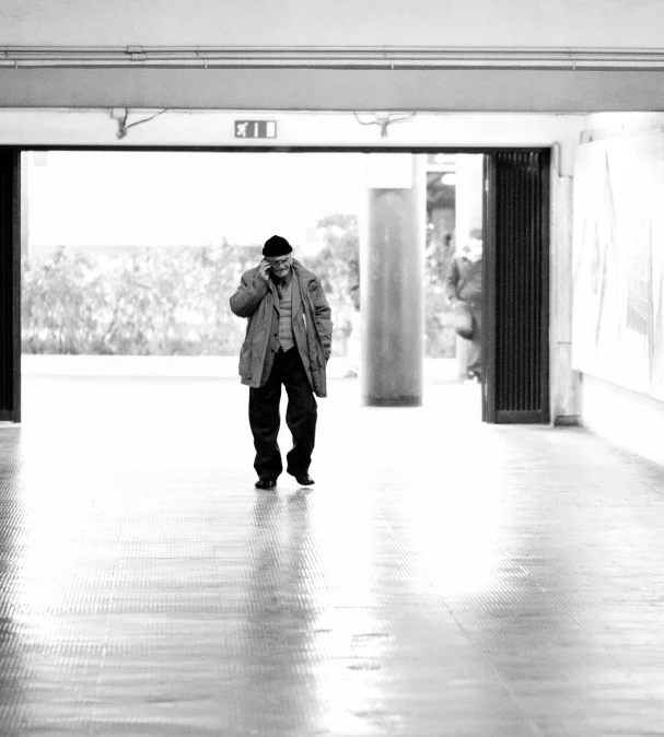 a man walking through an open door in a building