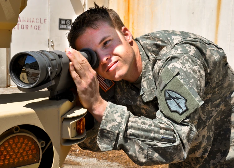 a young man is posing for a picture while holding a gun and scope