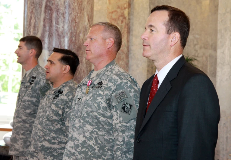 a group of men in uniform standing in front of a tv
