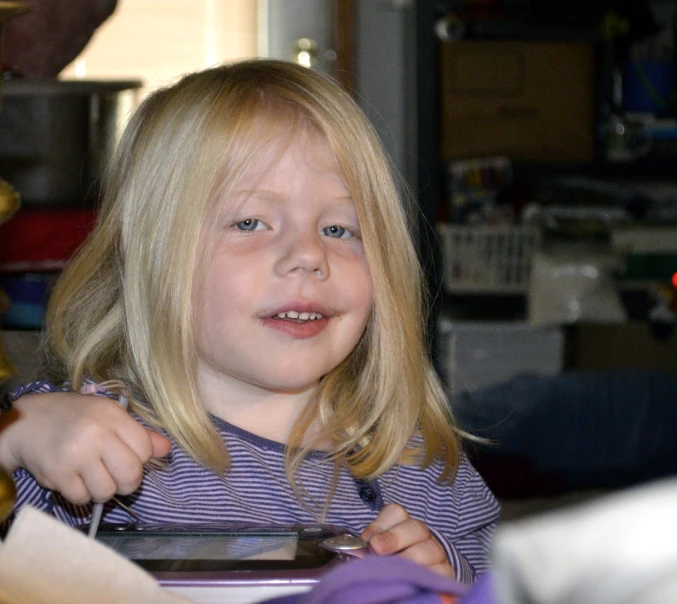 a child with a knife smiles in front of some other children