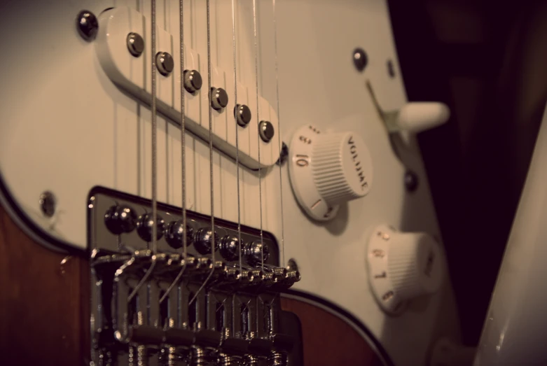 close up of strings on a white electric guitar