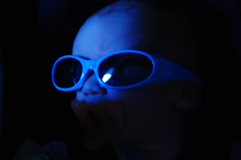 a baby wearing glasses, covered in bright light