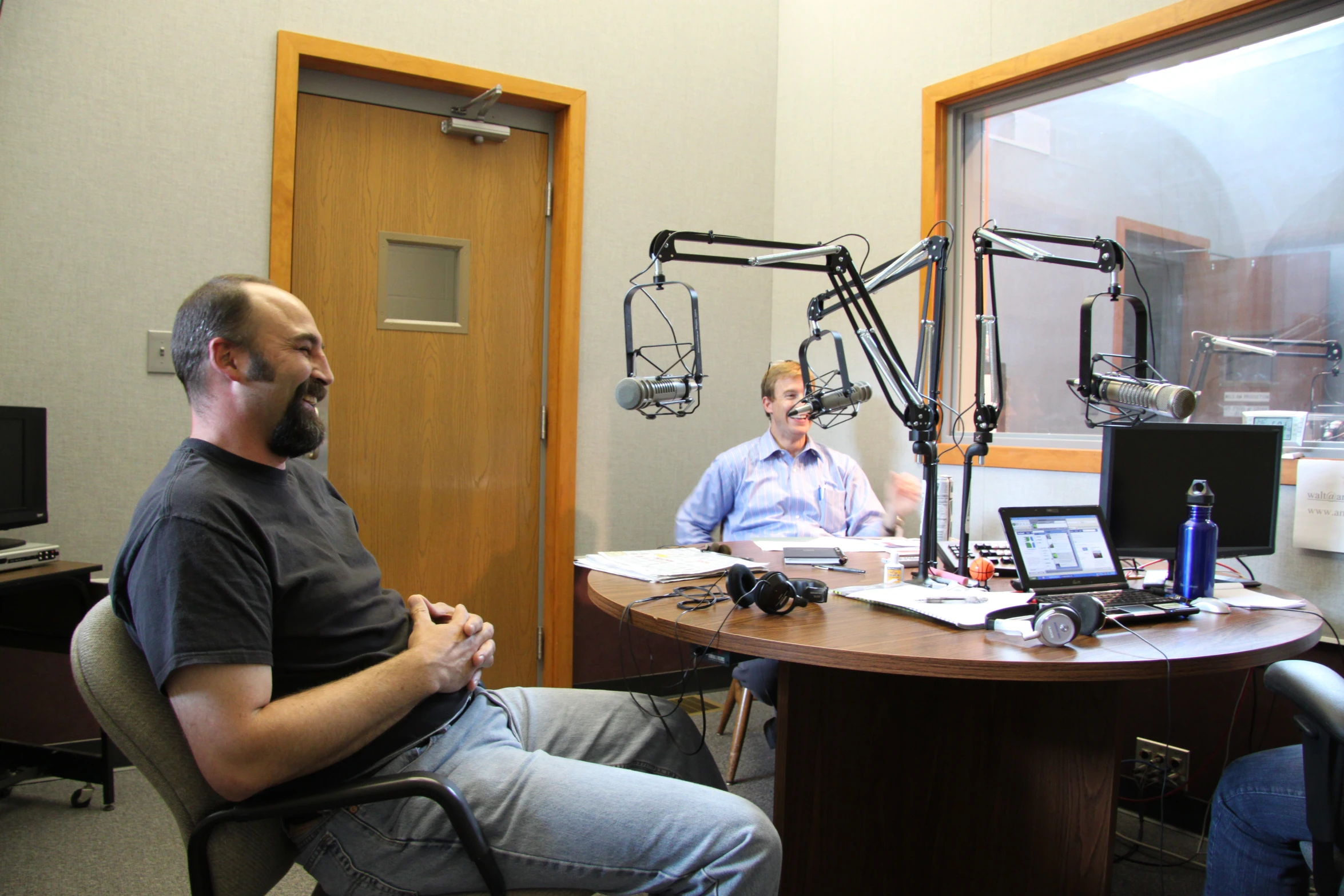 two men sit in front of an equipment desk