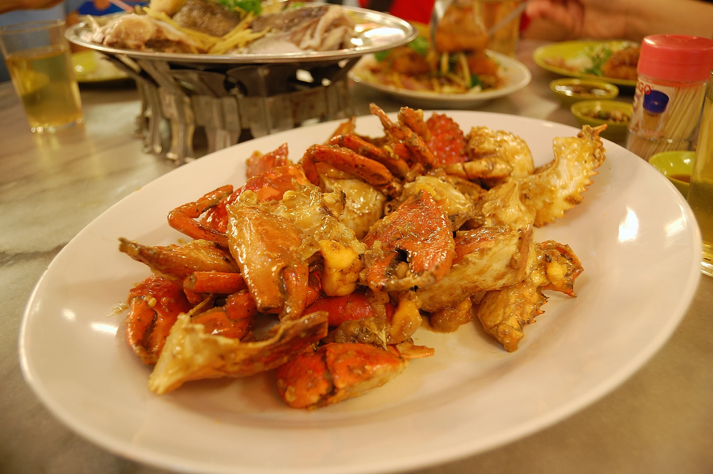 cooked seafood in white plate on table with plates of food