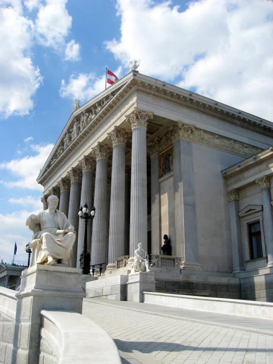 statue on pedestal next to columns and a flag