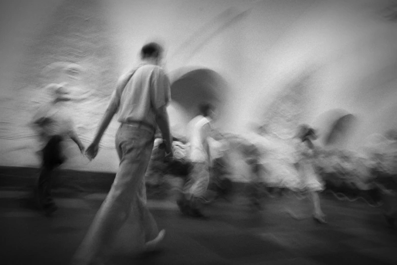 blurry pograph of people walking on pavement