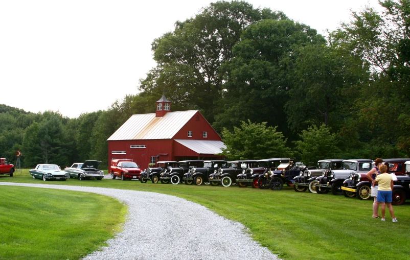 a red barn surrounded by lots of parked cars