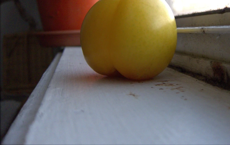 an orange sits on the ledge in front of a window