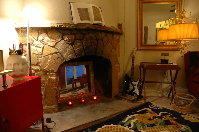 there are candles in the fireplace between two small tables