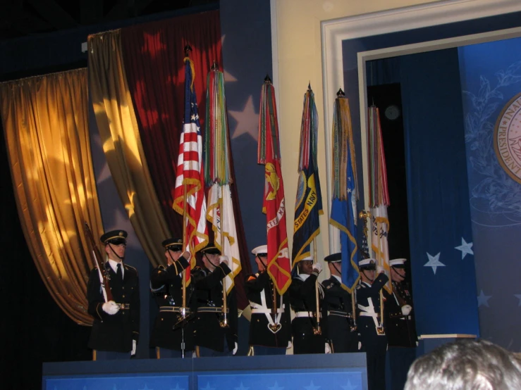 a few men in military uniform are performing a speech