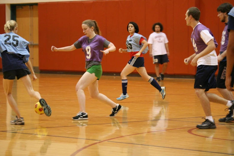 several girls are playing soccer on a court