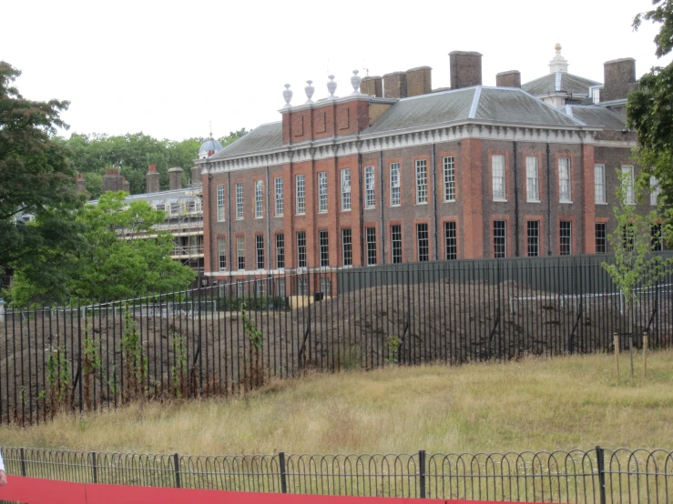 a large building in a field behind a fence