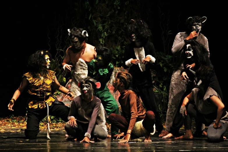 a group of people on a stage performing animal dances