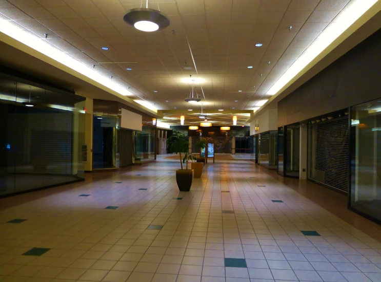 the long hallway has white tiled floors and lights