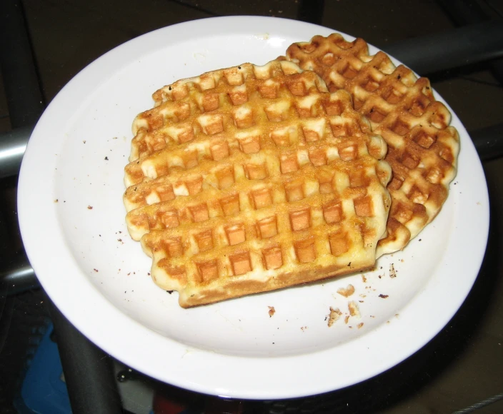 a waffle on a plate next to a cup on the table