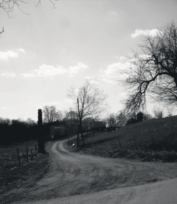 an empty road in the middle of a field