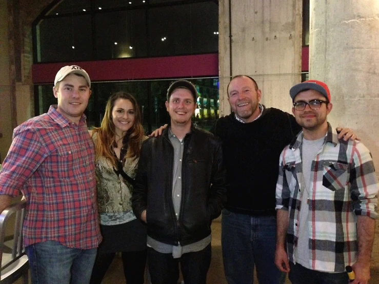 five people standing together smiling and posing for the camera