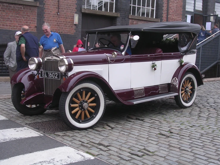 an old - fashioned antique car is on display at an outdoor event